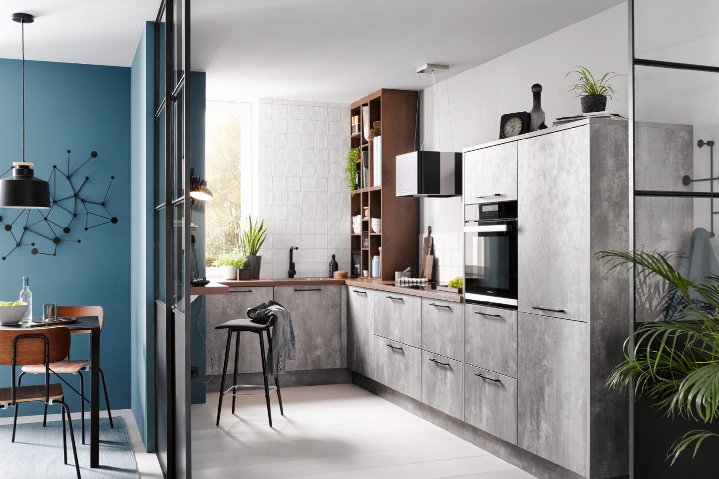 Moderne L-förmige Küche in Betonoptik mit warmen Holzakzenten, Einbaugeräten und heller Arbeitsplatte