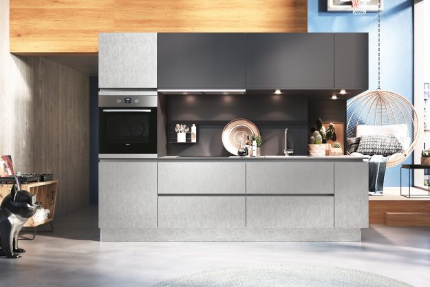 Moderne Küche mit Edelstahlfronten, dunkler Rückwand und gemütlichem Sitzbereich mit Hängesessel.