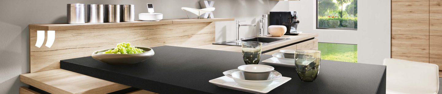 Moderne Designküche mit Holzelementen, Glasgeschirr und eleganter Arbeitsplatte