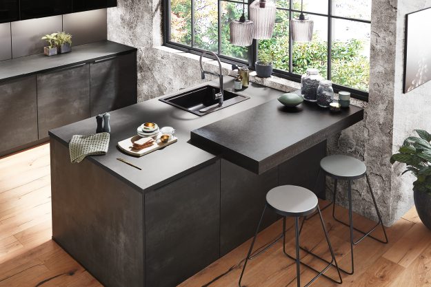 Moderne Küche in Betonoptik mit dunkler Arbeitsplatte und Holzdetails.