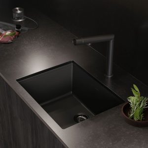 Edles schwarzes Spülbecken mit moderner Armatur und dunkler Arbeitsplatte