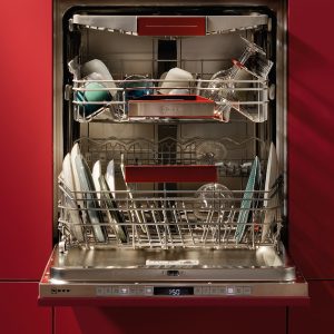 Eine offene Spülmaschine in einer modernen Küche mit roten Fronten.