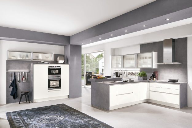 Moderne Küche in Weiß und Grau mit klaren Linien und funktionalem Design.