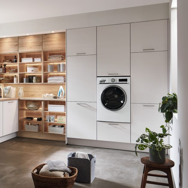 Moderne Hauswirtschaftsküche mit Waschmaschine und Regalen