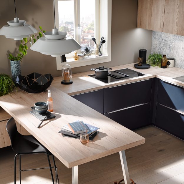 Moderne Küche mit heller Holzarbeitsplatte und Sitzbereich