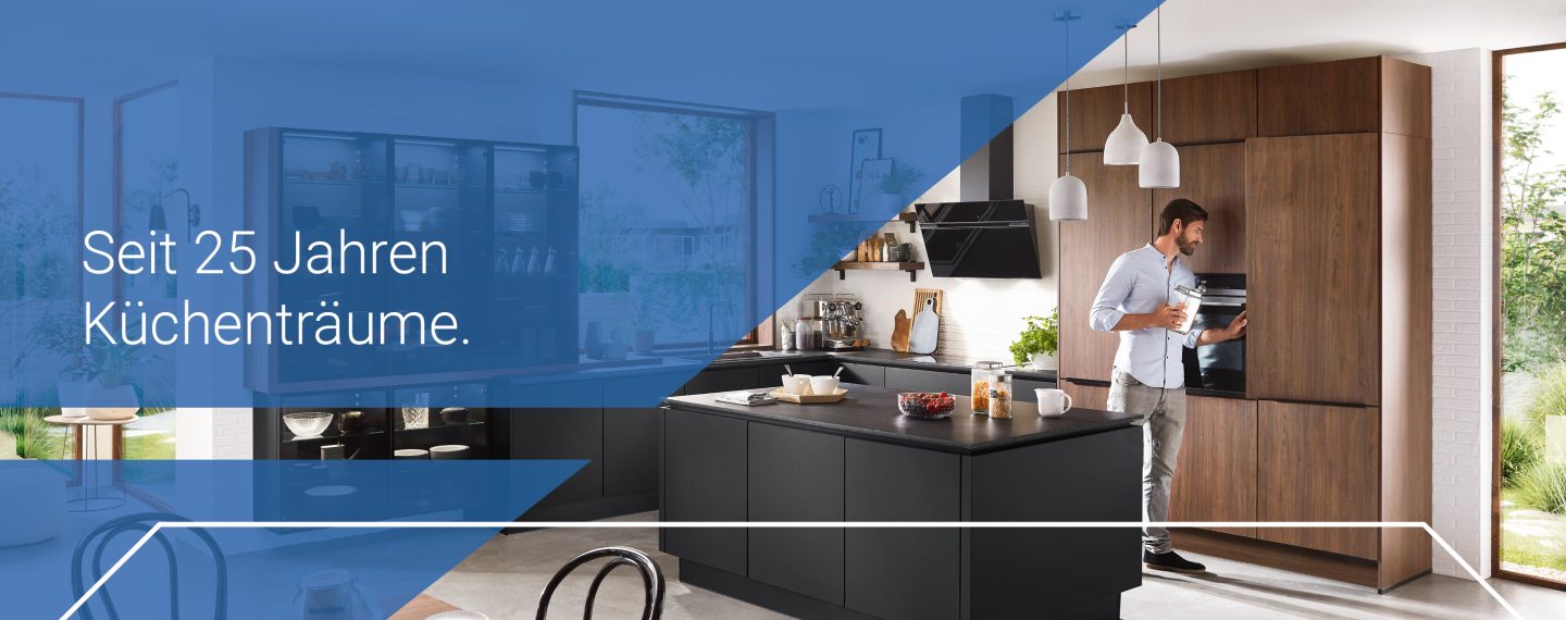 Moderner Küchenraum mit Holz- und Schwarzelementen, in dem ein Mann Kaffee zubereitet – Textaufschrift „Seit 25 Jahren Küchenträume“